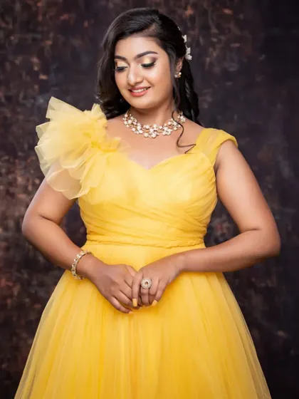 A happy client looking like sunshine in this bright yellow tulle gown. The one-shoulder design with a ruffle detail is playful and elegant.