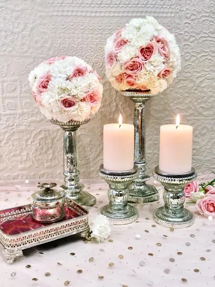 Light up your home in style with these chic mercury glass candle stands. Paired here with floral arrangements, they are a must-have for any modern wedding or festive decor.