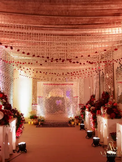 The pathway to a celebration should build anticipation. I lined this entrance with lush red rose arrangements and created a ceiling of hanging white florals to set a magical, elegant tone from the very first step.