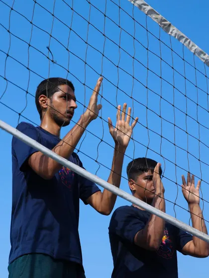 A close-up on blocking form. Notice the hand position and intense focus as players learn to anticipate the hit and protect their court.
