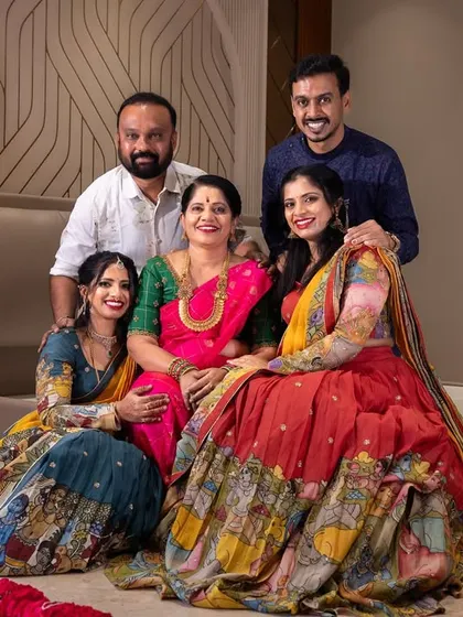 A formal family portrait taken during a housewarming, with everyone dressed in festive attire, celebrating this important milestone together.