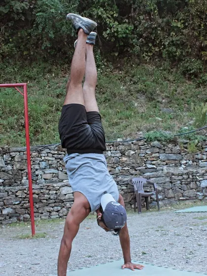 Practicing handstands outdoors. Bodyweight training can be done anywhere, connecting your fitness routine with nature.