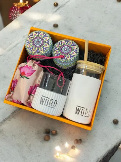 This corporate gift set for 'WORD' features a branded borosilicate glass and sipper, along with decorative tins, presented in a vibrant yellow box. It's a great example of practical and eye-catching branding.