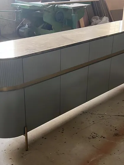 We can't get over this beauty. A classic sideboard with a curved form, fluted details, and a metal-trimmed waist, seen here in our workshop.