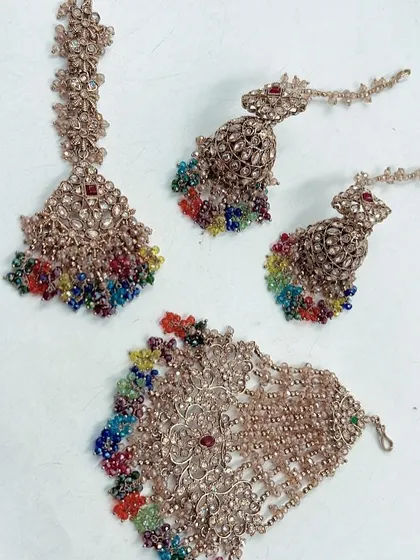 Brighten up your pre-wedding functions with my special Haldi and Mehendi collection. This set features a maang tikka, hath phool, and earrings with vibrant, multi-color beads that will perfectly complement your festive outfits.