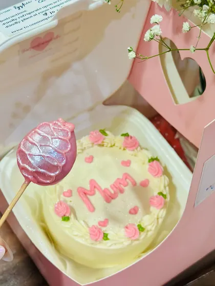 A customer's view of our Mother's Day hamper, showing the bento cake and a cake pop. The cake is decorated with piped roses and the message 'Mum'.