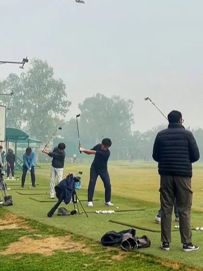 Golfers in their natural habitat on a foggy morning, still getting their practice in.