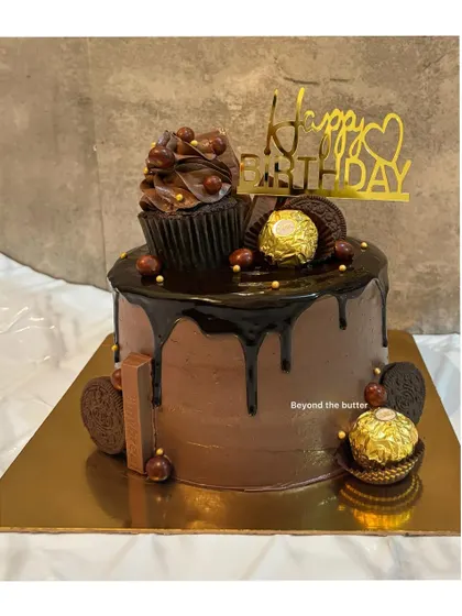 This chocolate overloaded cake is pure indulgence. It's topped with a chocolate cupcake, Ferrero Rocher, Oreos, and has a rich chocolate drip.