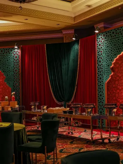 The buffet area, designed to be as beautiful as the rest of the venue. The backdrop features emerald green jali screens and red textured panels, ensuring every corner of the space is thematically cohesive.