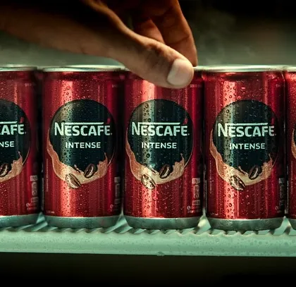 A product-focused shot of Nescafé Intense cans in a cooler. This visual reinforces the idea of a cool, refreshing drink perfect for any time.