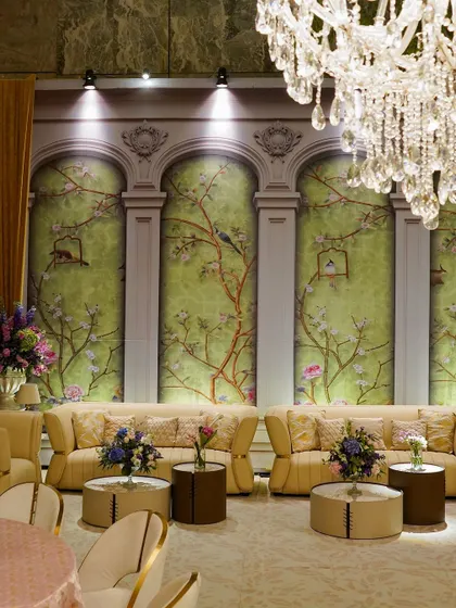 A view of the lounge seating, with the magnificent crystal chandelier hanging overhead. The lighting and decor create a sophisticated and luxurious atmosphere.