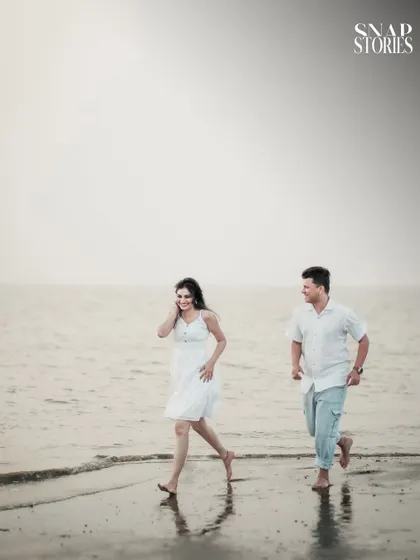 A fun, action shot of the couple running along the shoreline, adding a sense of energy and playfulness to their pre-wedding photography collection.