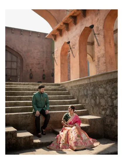 A candid shot of the couple sitting on the steps of a historic building, sharing a quiet moment during their pre-wedding session.