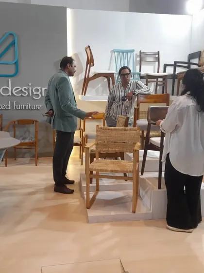 Visitors exploring the "chair wall" at my booth, where I displayed a wide range of seating designs, from modern to classic.