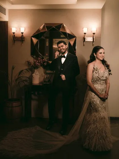 A playful and stylish reception portrait, with the groom pretending to be on the phone while his bride waits.