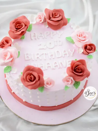 A classic and beautiful floral cake. This design features a wreath of hand-made sugar roses in shades of pink and red, perfect for a 20th birthday.