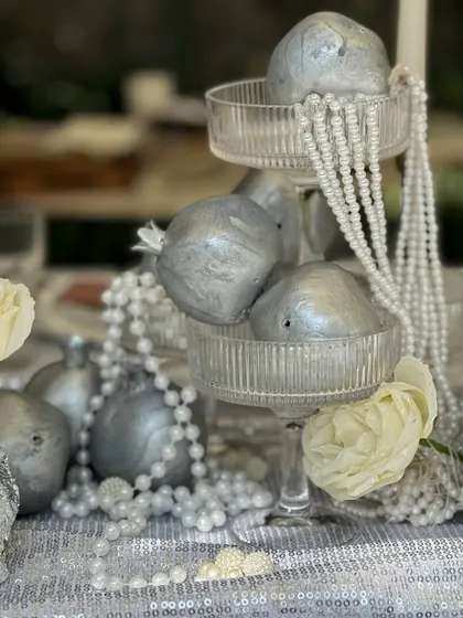A close-up of the tiered stand with silver pomegranates and pearls, a perfect example of how we style with creativity and elegance.