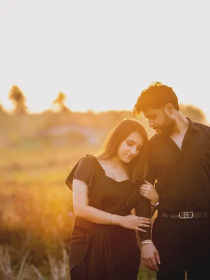 A silhouette of a couple against the setting sun. This romantic pre-wedding shot uses the natural light to create a dreamy and atmospheric portrait.