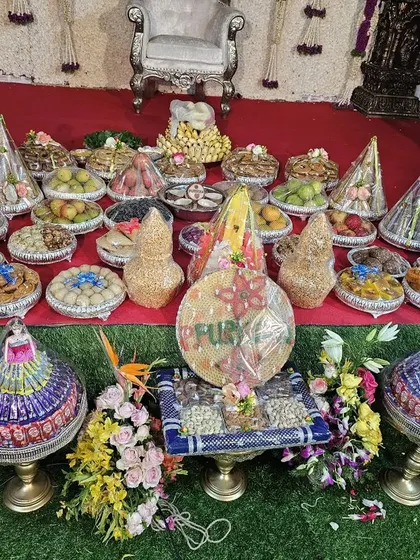 A grand display of decorated fruit trays and platters for a 'seemanta' or half-saree function. Each platter is carefully wrapped and arranged to look abundant and beautiful.