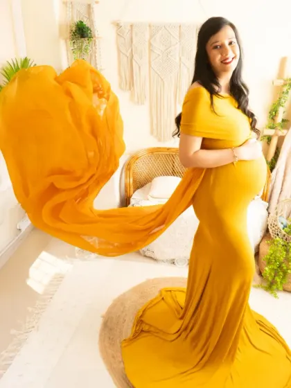 A dynamic shot of the yellow gown with the fabric in mid-air. This technique adds energy and a "wow" factor to your maternity photos.