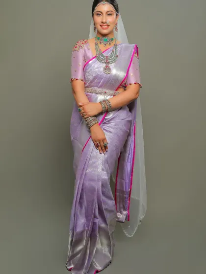 A full-length view of the lavender saree, its shimmering silver zari and pink border creating a modern and elegant look.