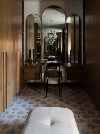 The master walk-in closet at Pràna, designed for her. The arched mirrors, patterned carpet, and warm wood create a soft, feminine, and luxurious dressing area.