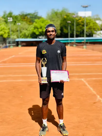 Oges posing on the clay court with his singles trophy from the Sivakasi tournament.