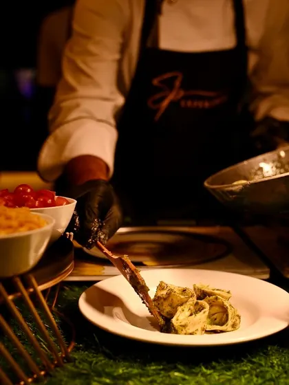 A chef carefully plates a serving of three-cheese stuffed tortellini, ensuring an elegant presentation for each guest.