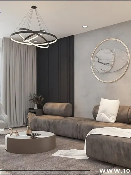 This seating area from the 'Zen Glam' project uses a plush, oversized sofa in a calming grey tone. The large window allows for plenty of natural light, while the abstract wall art adds a touch of modern sophistication.