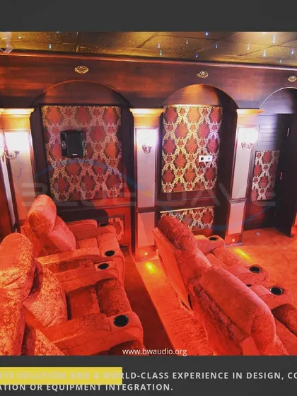 This angle showcases the plush, oversized recliners and detailed wall architecture of a classic home cinema. Every element, from the patterned fabric to the warm lighting, is chosen to enhance comfort and luxury.