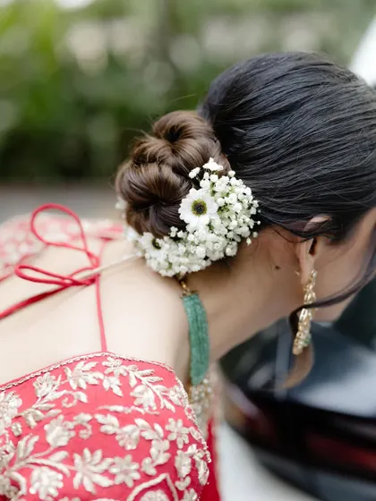 A closer view of the floral arrangement on this twisted bun. I love how the small white flowers create a delicate halo effect, adding a touch of magic to the bride's look.
