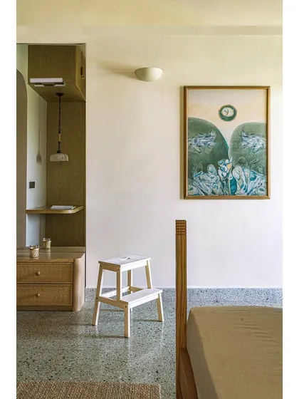 A bedroom in Apartment 5026, featuring the original reclaimed terrazzo floor and a mix of vintage and modern furniture.