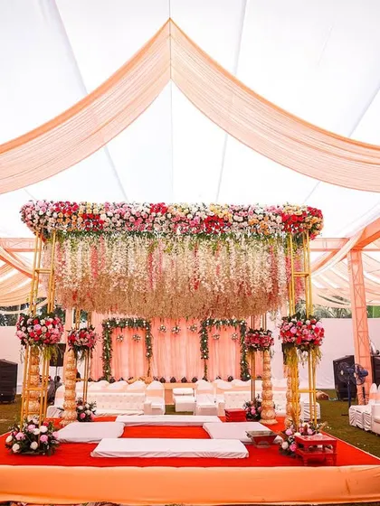 A frontal view of the beautiful mandap, showcasing the hanging floral chandeliers and the grand scale of the setup.