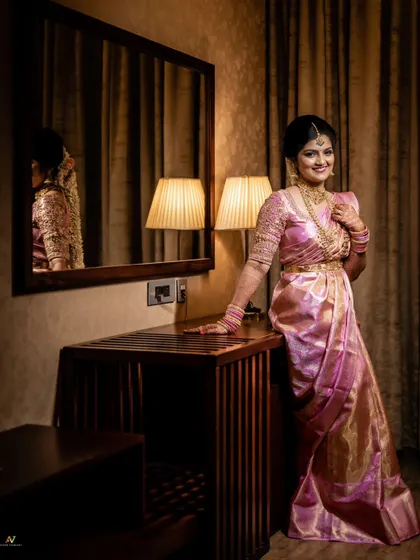 An elegant bridal portrait, with the bride posing by a mirror, her reflection adding depth to the shot.