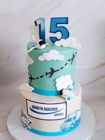 A corporate cake for a 15th anniversary. This two-tier design features an aviation theme to celebrate the company's milestone.