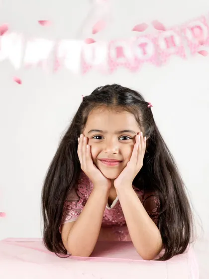 A sweet and simple portrait of the birthday girl. Her genuine smile and the soft pink background make this a timeless photo from her fifth birthday shoot.