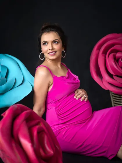 A stunning solo portrait of the expecting mother, framed by giant paper flowers for a whimsical and artistic touch.