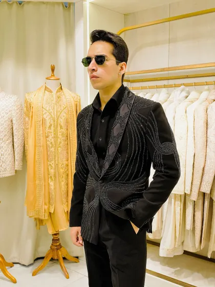 A front view of the black embellished blazer, showing how the intricate beadwork frames the lapels and creates a sophisticated, textured look.