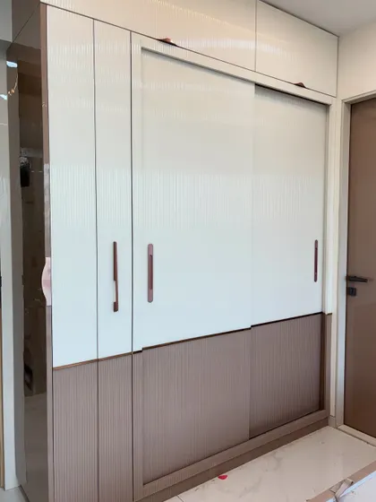 A closer look at the wardrobe, highlighting the different textures and the slim, modern handles.