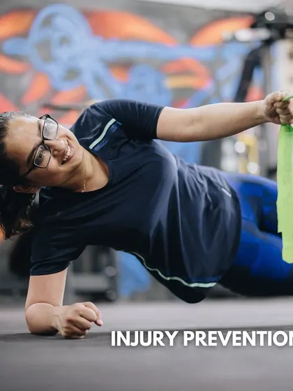 A client smiles while holding a side plank with a band row. Our programs focus on building hybrid fitness, incorporating strength, mobility, and injury prevention.