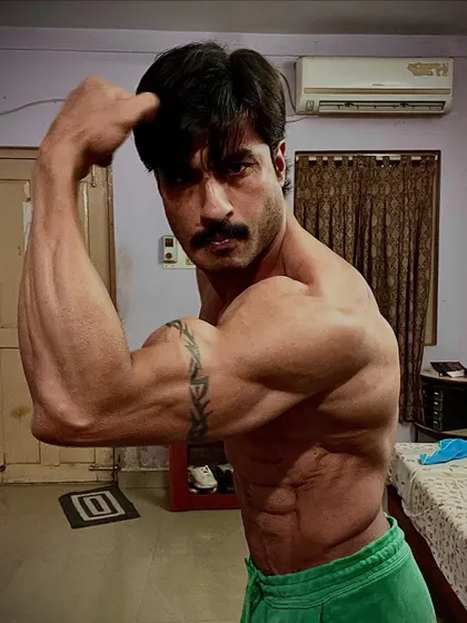 A shredded bicep pose from the front. This level of conditioning reveals every muscle fiber and vein.