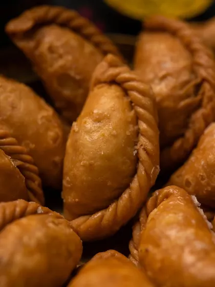 A close-up macro shot of a Gujjiya. This allows the viewer to appreciate the texture and craftsmanship of the sweet, making it look even more delicious.