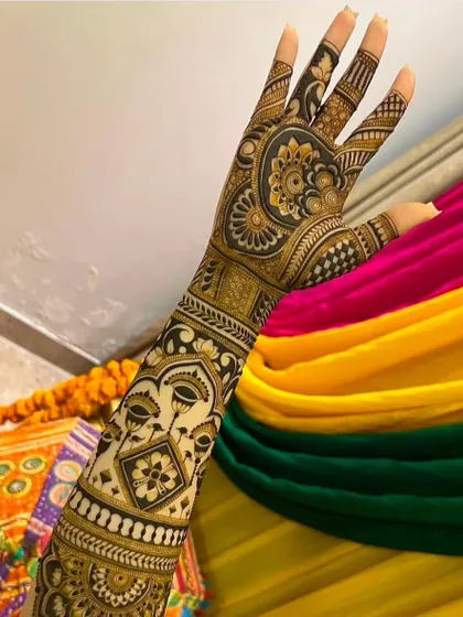 A unique design featuring a face motif with a lotus, combined with geometric and floral patterns. This is a great example of modern, artistic mehndi.