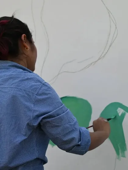 A shot of me painting a large mural. This is me in my element, fully immersed in the process of creating.