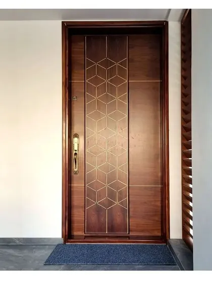 A close-up of a main door with a beautiful geometric brass inlay.