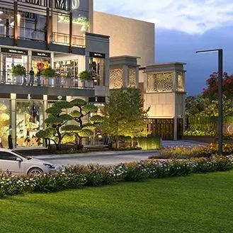 An evening view highlighting the architectural lighting and feature elements of the facade. The illuminated entrance and decorative screens add a layer of sophistication and visual interest to the building after dark.