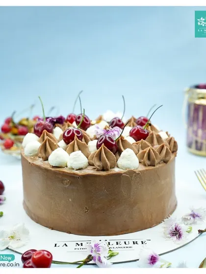 Another view of my classic Black Forest cake, showcasing the beautiful arrangement of fresh cherries and cream swirls set against the rich chocolate frosting.