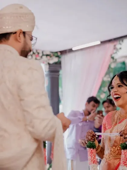 A candid shot of the bride's laughter during the garland exchange ceremony.