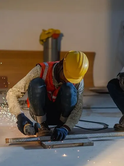 Precision in action. Two of our skilled workers are on-site, with one carefully cutting metal while the other supervises, showcasing the craftsmanship that goes into every project.