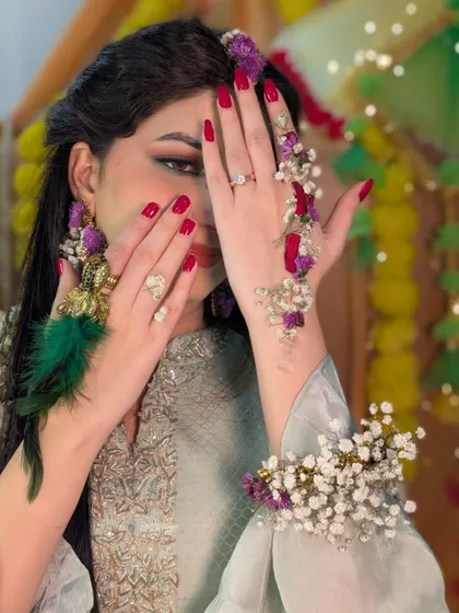 A playful shot showing off the floral haath phool and bright red nails.